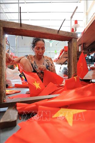 Nghề thêu, may cờ Tổ quốc vẫn được các thế hệ người làng Từ Vân giữ gìn và phát triển. Ảnh: Khánh Hòa – TTXVN 