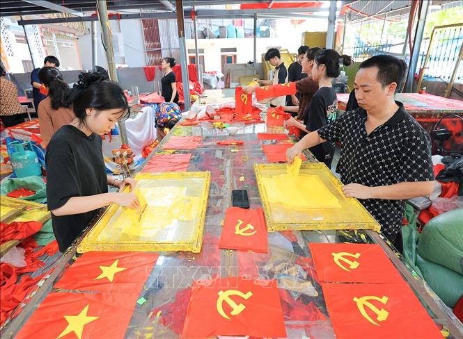 Từng công đoạn, từng lá cờ được người dân nơi đây thực hiện một cách tỉ mỉ. Ảnh: Lê Đông - TTXVN 