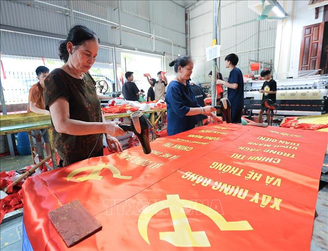 Từng công đoạn, từng lá cờ được người dân nơi đây thực hiện một cách tỉ mỉ. Ảnh: Lê Đông - TTXVN 