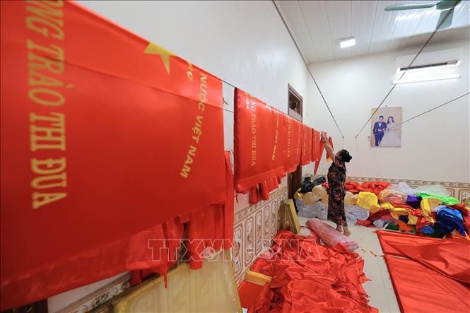 Từng công đoạn, từng lá cờ được người dân nơi đây thực hiện một cách tỉ mỉ. Ảnh: Lê Đông - TTXVN 
