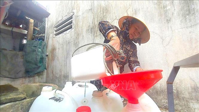 Người dân làng chài Minh Hải phải chắt nước ngọt vào từng can để tích trữ và sử dụng. Ảnh: Quang Thái - TTXVN