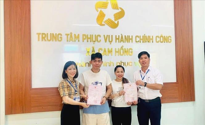 Lãnh đạo UBND xã Cam Hồng (Quảng Trị) trao giấy Chứng nhận đăng ký kết hôn cho công dân tại Trung tâm phục vụ hành chính công xã. Ảnh: TTXVN phát
