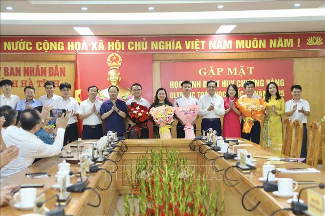 Lãnh đạo tỉnh HàTĩnh tặng hoa chúc mừng 2 học sinh Trần Minh Hoàng, Võ Trọng Khải và cán bộ ngành Giáo dục Hà Tĩnh. Ảnh: TTXVN phát