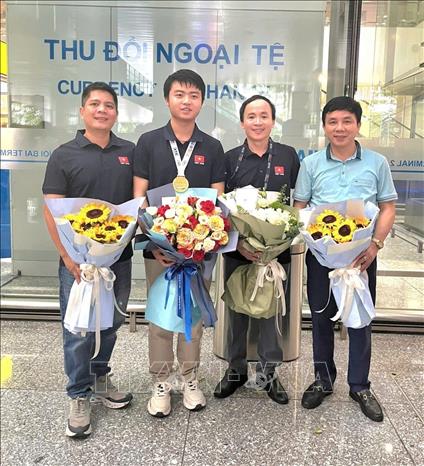Em Võ Trọng Khải cùng người thầy giáo bồi dưỡng Phan Văn Thái và các thầy bồi dưỡng trọng đội tuyển Olympic. Ảnh: TTXVN phát