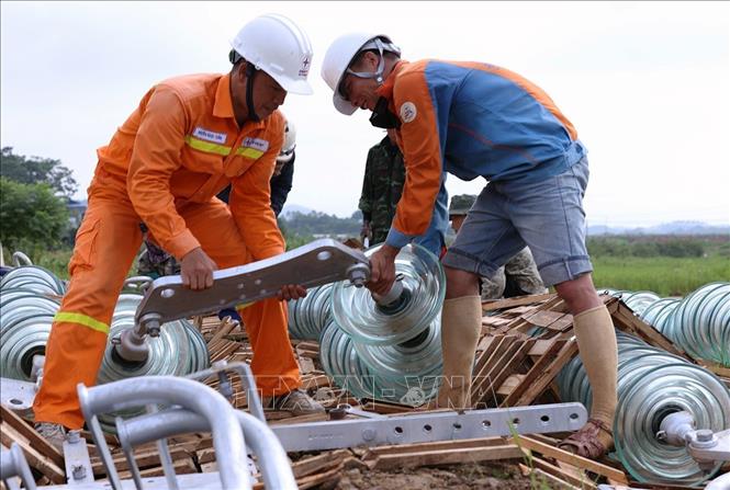 Lắp đặt sứ cách điện trước khi được treo lên vị trí cột số 352, ở xã Vũ Ninh, thuộc địa bàn xã Vũ Ninh, tỉnh Phú Thọ. Ảnh: Vũ Sinh - TTXVN