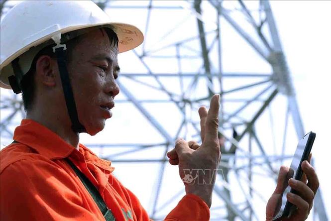 Công nhân Chu Văn Xuân, Công ty Cổ phần Tập đoàn Đầu tư thương mại công nghiệp Việt Á, tranh thủ gọi điện cho người thân trong lúc nghỉ. Ảnh: Vũ Sinh - TTXVN