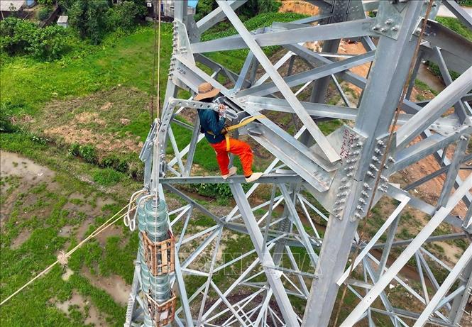 Lắp đặt trụ sứ cách điện ở vị trí cột số 352, thuộc địa bàn xã Vũ Ninh, tỉnh Phú Thọ. Ảnh: Vũ Sinh - TTXVN