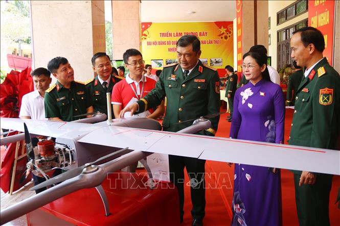 Lãnh đạo Quân khu 7 cùng các đại biểu tham quan mô hình, trang thiết bị quân sự trưng bày bên lề Đại hội. Ảnh: Lê Xuân-TTXVN