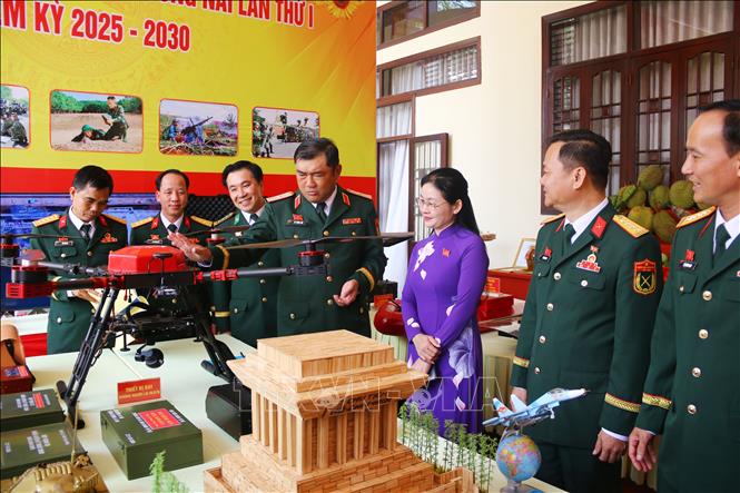 Lãnh đạo Quân khu 7 cùng các đại biểu tham quan mô hình, trang thiết bị quân sự trưng bày bên lề Đại hội. Ảnh: Lê Xuân-TTXVN