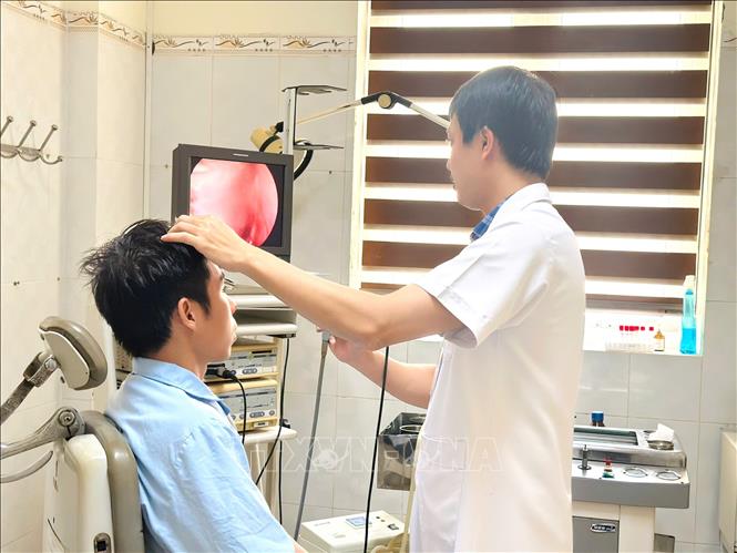 Bác sỹ Nguyễn Văn Hòa, Trưởng đơn nguyên Đầu cổ, Khoa Tai mũi họng (Bệnh viện Đa khoa tỉnh Thanh Hoá) thăm khám cho bệnh nhân sau phẫu thuật. Ảnh: TTXVN phát