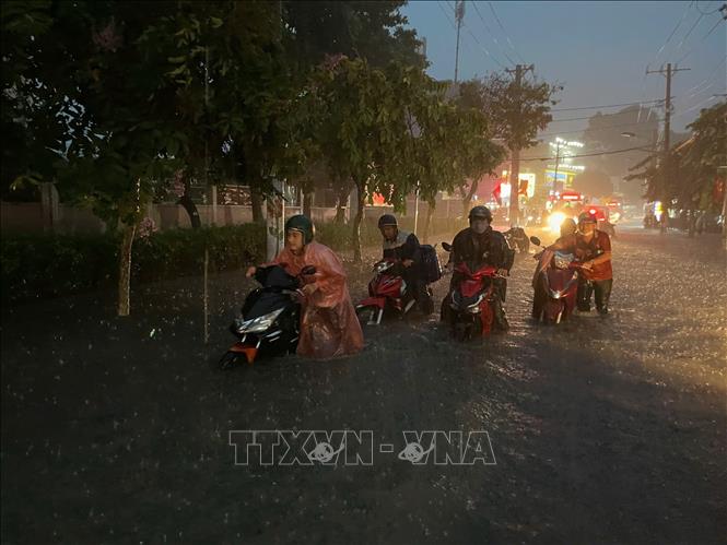 Người dân di chuyển khó khăn qua vùng ngập nước trên đường Tô Ngọc Vân (TP. Hồ Chí Minh). Ảnh: TTXVN phát
