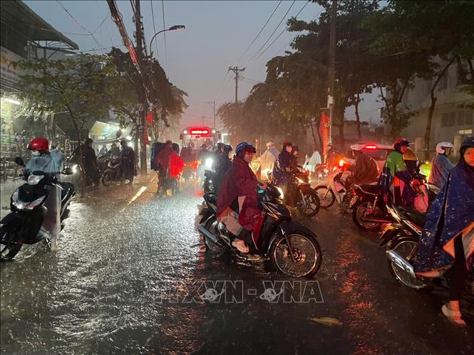 Người dân Thành phố Hồ Chí Minh chọn giải pháp di chuyển hướng đi khác khi thấy đường ngập nước, chiều tối 5/8/202. Ảnh: TTXVN phát