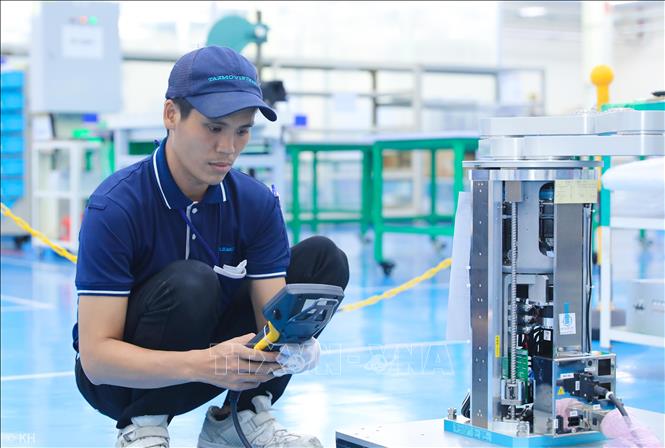 Công nhân kiểm tra robot trung chuyển wafer trong ngành bán dẫn. Ảnh: Thành Phương – TTXVN
