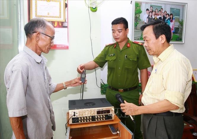 Thượng sĩ Nguyễn Văn Hùng, Cảnh sát khu vực  phường An Khê, quận Thanh Khê, thành phố Đà Nẵng trao đổi với ông Nguyễn Ngọc Hiến (bên trái), Tổ trưởng tổ dân phố số 167, phường An Khê và Nguyễn Văn Mười, Bí thư Chi bộ 3, khu vực Phần Lăng, phường An Khê về mô hình “Tiếng còi báo động vây bắt tội phạm”. Ảnh: Doãn Tấn - TTXVN