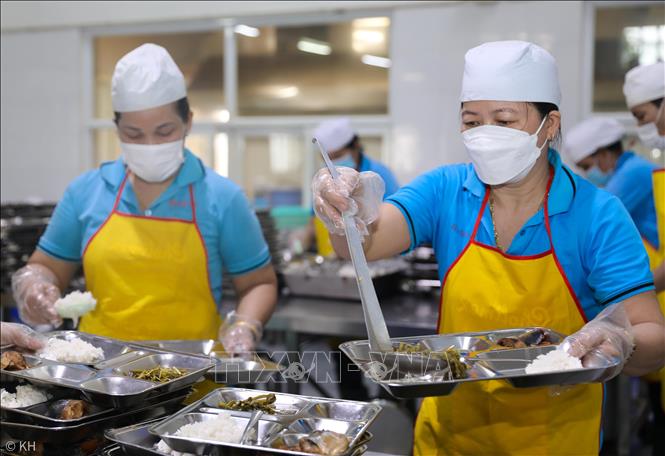 Nhân viên nhà bếp Công ty Giày Viễn Thịnh chuẩn bị sẵn các phần ăn để kịp phục vụ bữa trưa cho người lao động. Ảnh: Thành Phương - TTXVN