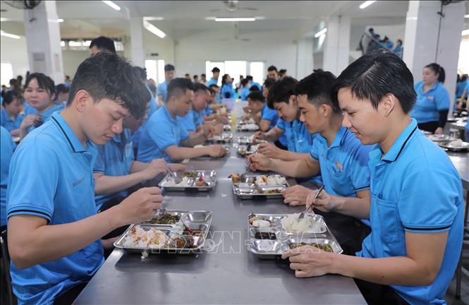 Nhiều công nhân phấn khởi khi được lãnh đạo Công ty quan tâm đến chất lượng và định lượng bữa ăn. Ảnh: Thành Phương – TTXVN