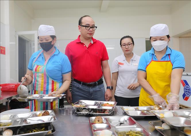 Lãnh đạo công ty Giày Viễn Thịnh giám sát quy trình định lượng và chất lượng bữa ăn cho người lao động. Ảnh: Thành Phương - TTXVN