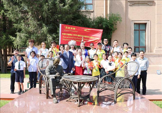 Thiếu nhi hai nước Việt - Trung cùng Lãnh đạo Đại sứ quán Việt Nam tại Trung Quốc chụp ảnh lưu niệm bên tượng đài Bác Hồ. Ảnh: Công Tuyên - PV TTXVN tại Trung Quốc