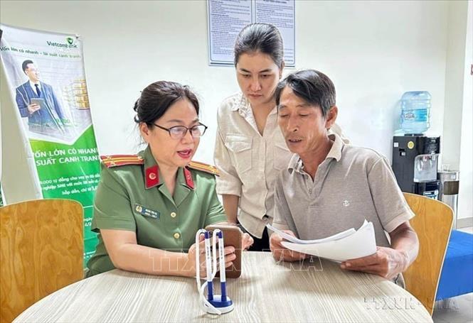 Cán bộ Phòng Hồ sơ (Công an tỉnh Đồng Nai) hướng dẫn người dân khai báo cấp phiếu lý lịch tư pháp trên điện thoại. Ảnh: TTXVN phát