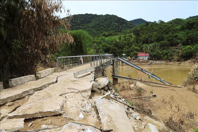 Cầu treo bản Lau (xã Tương Dương, tỉnh Nghệ An) bắc qua sông Lam nối với quốc lộ 7 bị lũ kéo đổ sập, cuốn trôi gây cô lập hàng trăm hộ dân. Ảnh: Xuân Tiến - TTXVN 