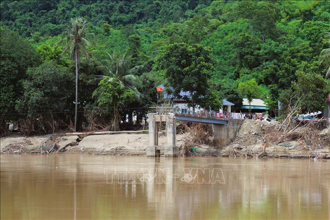 Phần còn lại của cầu treo bản Lau (xã Tương Dương, tỉnh Nghệ An) và khu dân cư bị cô lập với quốc lộ 7 nằm phía bên kia sông Lam. Ảnh: Xuân Tiến - TTXVN 