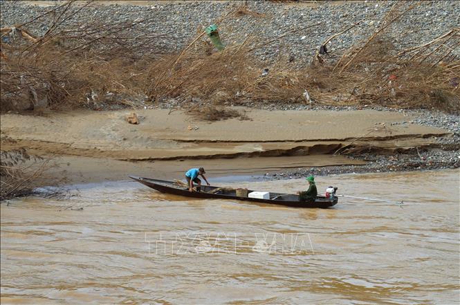 Cầu treo bụ lũ cuốn trôi, người dân vùng cô lập phải dùng thuyền bé có gắn động cơ công suất nhỏ để di chuyển qua sông Lam, sông Nậm Mộ...nhận như yếu phẩm, lương thực tư hoạt động cứu trợ của các đoàn thiện nguyện. Ẩnh: Xuân Tiến - TTXVN 
