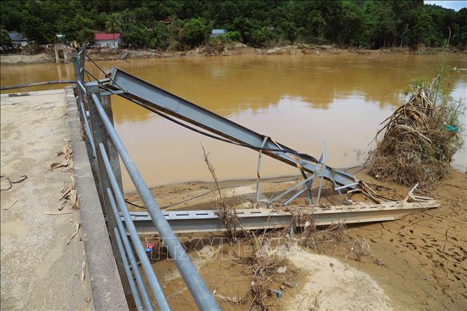 Hệ thống cột trụ cầu treo bản Lau bị kéo đổ sập còn nằm trơ trọi trên bờ sông Lam. Ảnh: Xuân Tiến - TTXVN 