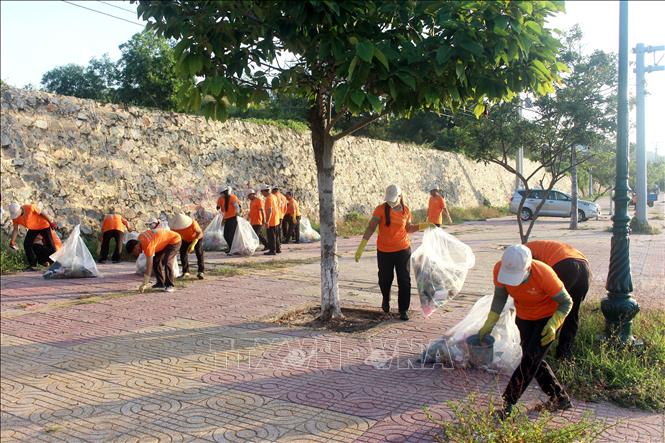 Các nhân viên tham gia dọn dẹp vệ sinh các tuyến đường và khu vực công cộng xung quanh khu du lịch. Ảnh: Hồng Hiếu- TTXVN