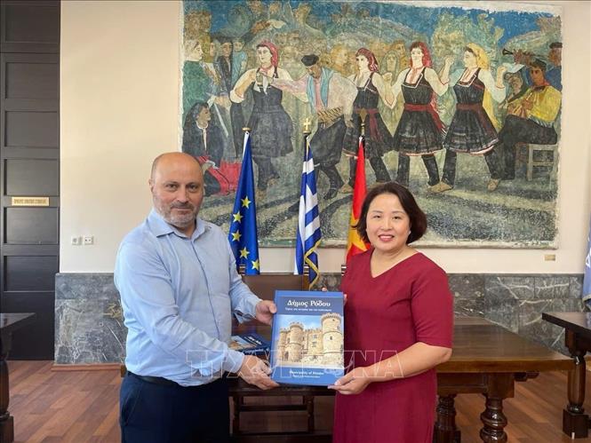 Phó Thị trưởng đảo Rhodes Chalkias Konstantinos tặng sách cho Đại sứ Phạm Thị Thu Hương. Ảnh: TTXVN phát
