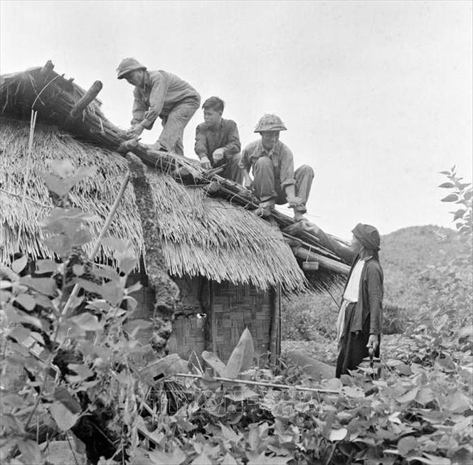 Chiến sĩ công an vũ trang trên đảo (Quảng Ninh) giúp nhân dân sửa chữa nhà cửa để chống bão (1969). Ảnh: Minh Trường - TTXVN

