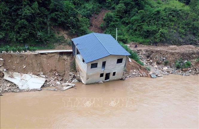 Mưa lớn gây lũ ống, lũ quét, sạt lở đất khiến một hộ gia đình phải di dời khẩn cấp, nhà cửa bị sụt sạt xuống suối. Ảnh: Quang Quyết - TTXVN