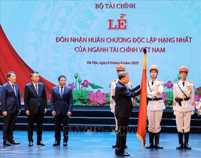 Tổng Bí thư Tô Lâm gắn Huân chương Độc lập hạng Nhất lên Cờ truyền thống ngành Tài chính. Ảnh: Phạm Hậu - TTXVN