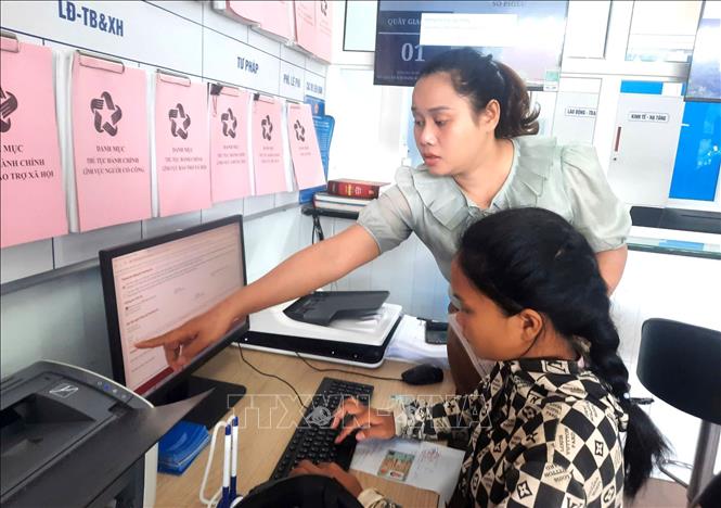 Cán bộ, công chức xã Hướng Hiệp (Quảng Trị) hỗ trợ người dân thực hiện các thủ tục hành chính tại Trung tâm phục vụ hành chính công xã. Ảnh: TTXVN phát