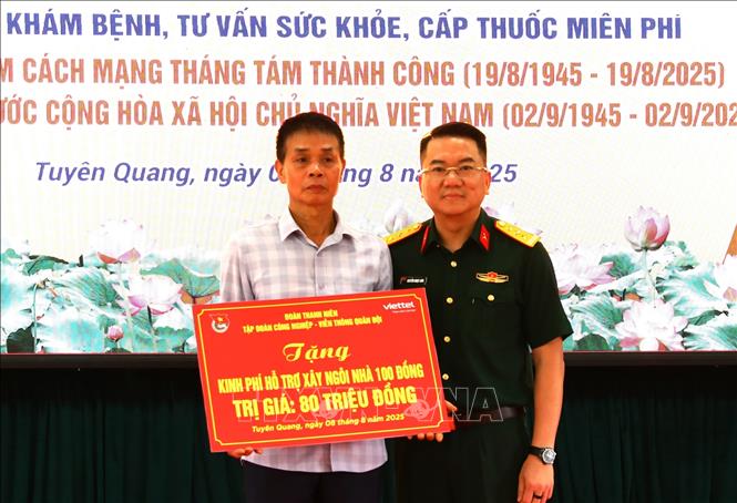 Thượng tá Nguyễn Ngọc Linh, Phó Chủ nhiệm Chính trị Tập đoạn Công nghiệp - Viễn thông Quân đội (Viettel) trao biểu trưng “ngôi nhà 100 đồng” cho hộ quân nhân có hoàn cảnh khó khăn ở xã Tân Trào, tỉnh Tuyên Quang. Ảnh: Minh Tâm - TTXVN