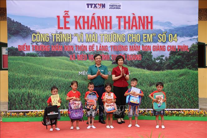 Bí thư Đảng ủy, Tổng Giám đốc TTXVN Vũ Việt Trang và Tổng biên tập Báo Thể thao và Văn hóa Nguyễn Thiện Thuật tặng quà cho trẻ em điểm trường Mầm non Đề Lảng. Ảnh: Huy Thông - TTXVN
