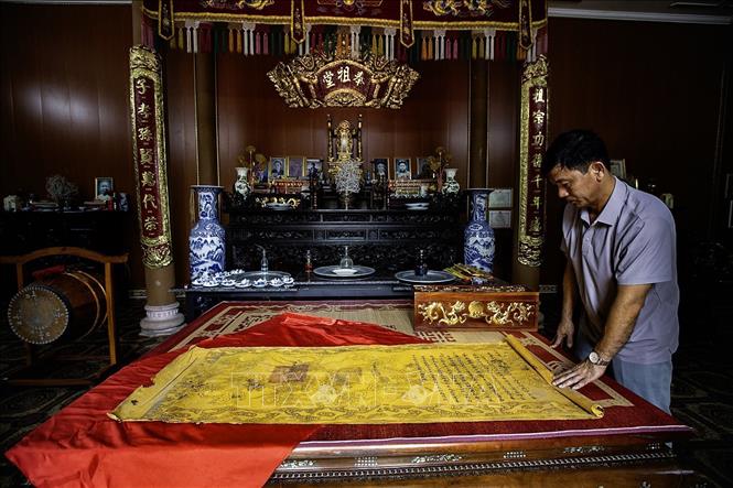 Anh Đinh Công Thảo cháu đời thứ 4 dòng họ Đinh Công tính từ Cụ Đinh Công Thịnh đảm nhiệm chức Tuần phủ Hòa Bình từ năm 1919–1928 bên các tờ sắc phong của vua ban cho dòng họ Đinh Công. Ảnh: Trọng Đạt-TTXVN