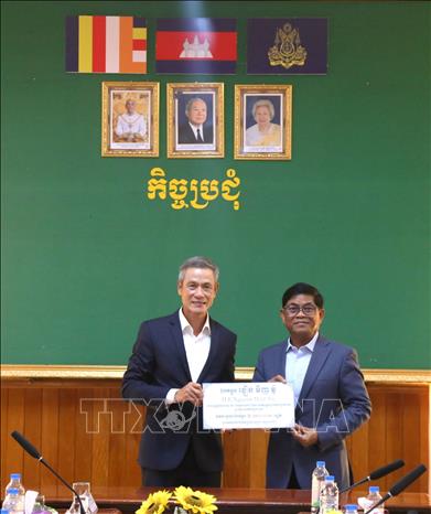 Đại sứ Nguyễn Minh Vũ (bên trái) trao tượng trưng quà tặng Hội Chữ thập đỏ tỉnh Ratanakiri. Ảnh: Huỳnh Thảo - PV TTXVN tại Campuchia
