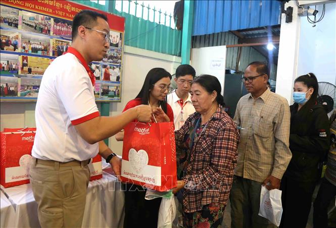 Nhân viên Công ty Viettel Cambodia (Metfone) trao tặng quà cho người dân tham gia chương trình. Ảnh: Huỳnh Thảo - PV TTXVN tại Campuchia 