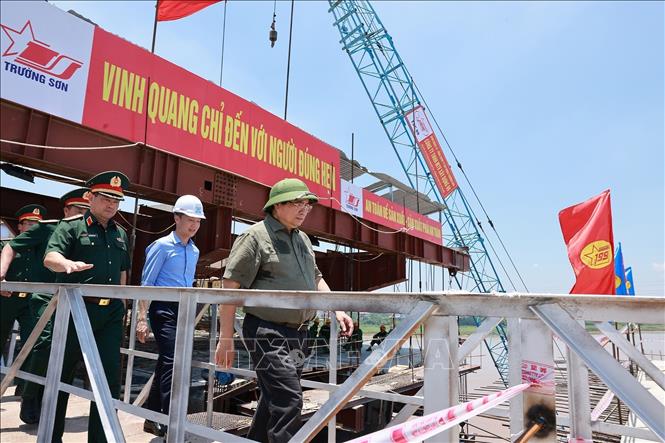 Thủ tướng Phạm Minh Chính kiểm tra tiến độ thi công cầu Phong Châu mới trên Quốc lộ 32C, tỉnh Phú Thọ. Ảnh: Dương Giang-TTXVN 
