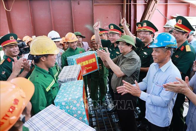 Thủ tướng Phạm Minh Chính và các đơn vị thi công thể hiện quyết tâm hoàn thành tiến độ thi công cầu Phong Châu. Ảnh: Dương Giang-TTXVN 
