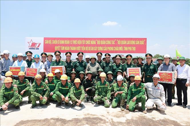Thủ tướng Phạm Minh Chính tặng quà động viên công nhân thi công cầu Phong Châu mới trên Quốc lộ 32C, tỉnh Phú Thọ. Ảnh: Dương Giang-TTXVN 
