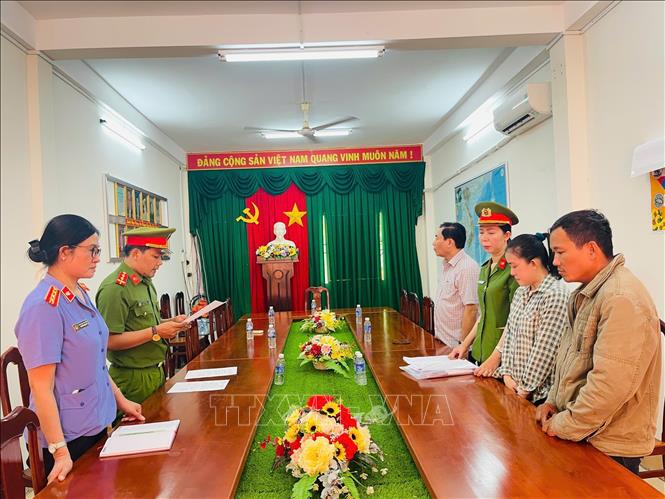 Cơ quan CSĐT tống đạt các quyết định tố tụng đối với Trần Mỹ Tiên (áo ca rô). Ảnh: TTXVN phát
