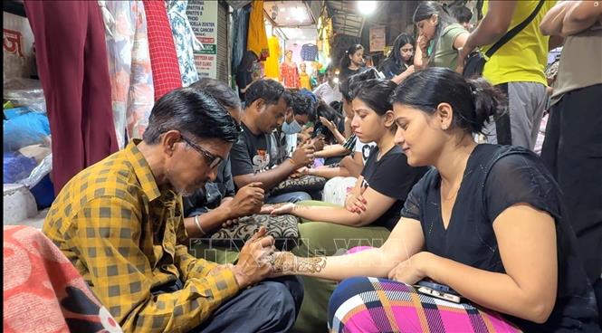 Các anh em trai dẫn các chị em gái đi vẽ Mehndi, còn được gọi là vẽ Henna. Ảnh: Ngọc Thúy - PV TTXVN tại Ấn Độ