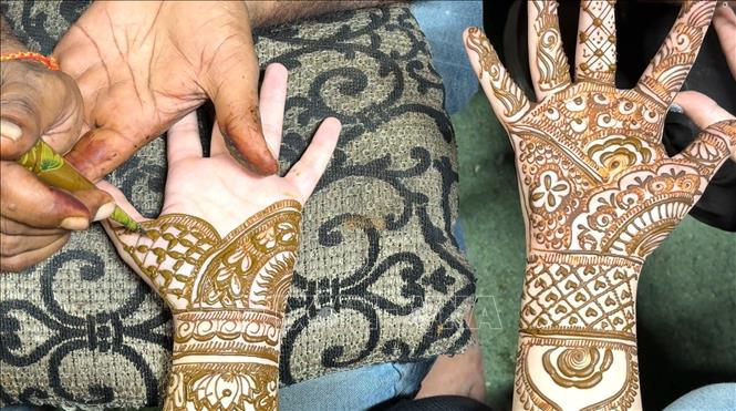 Anh em trai dẫn các chị em gái đi vẽ Mehndi, còn được gọi là vẽ Henna. Ảnh: Ngọc Thúy - PV TTXVN tại Ấn Độ