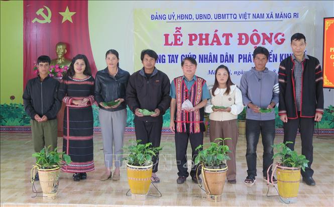 Các cán bộ, doanh nghiệp và người dân hỗ trợ hạt giống sâm Ngọc Linh cho bà con nhân dân xã Măng Ri. Ảnh: Dư Toán – TTXVN