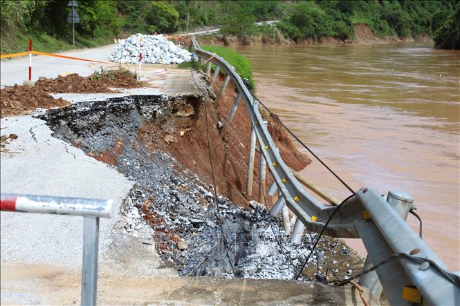 Điểm sạt lở ta-luy âm trên quốc lộ 7 do nước lũ sông Lam gây nên, quy mô điểm sạt đã ăn vào gần tim đường. Các loại xe ô tô lưu thông qua đây chỉ đi được 1 làn đường. Ảnh: Xuân Tiến - TTXVN 