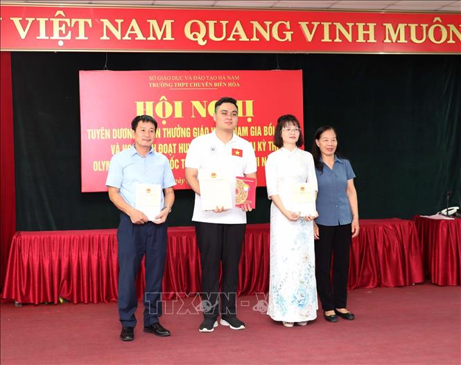 Em Đỗ Trung Kiên và giáo viên bồi dưỡng đội tuyển môn Hóa học Trường THPT chuyên Biên Hòa nhận khen thưởng sau khi em đoạt Huy chương Vàng kỳ thi Olympic Hóa học quốc tế Abu Rayhan Beruni 2025. Ảnh: Đại Nghĩa -TTXVN