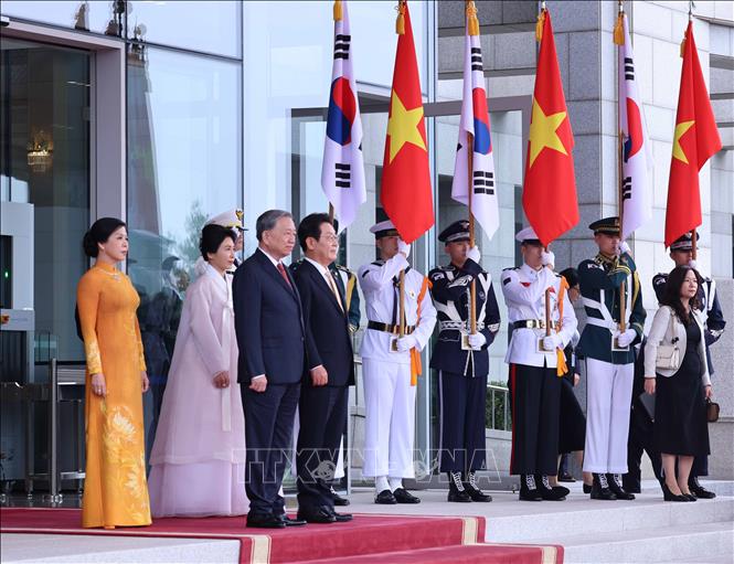 Tổng thống Hàn Quốc Lee Jae Myung và Phu nhân cùng Tổng Bí thư Tô Lâm và Phu nhân tại vị trí danh dự, nghe quân nhạc cử Quốc thiều hai nước. Ảnh: Thống Nhất - TTXVN