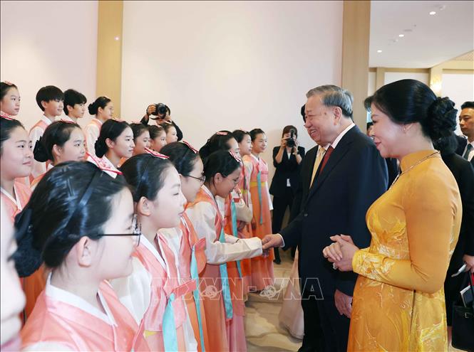 Tổng thống Lee Jae Myung và Phu nhân cùng Tổng Bí thư Tô Lâm và Phu nhân với thiếu nhi Hàn Quốc tại lễ đón. Ảnh: Thống Nhất - TTXVN