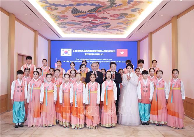 Tổng thống Lee Jae Myung và Phu nhân cùng Tổng Bí thư Tô Lâm và Phu nhân chụp ảnh chung với thiếu nhi Hàn Quốc tại lễ đón. Ảnh: Thống Nhất - TTXVN